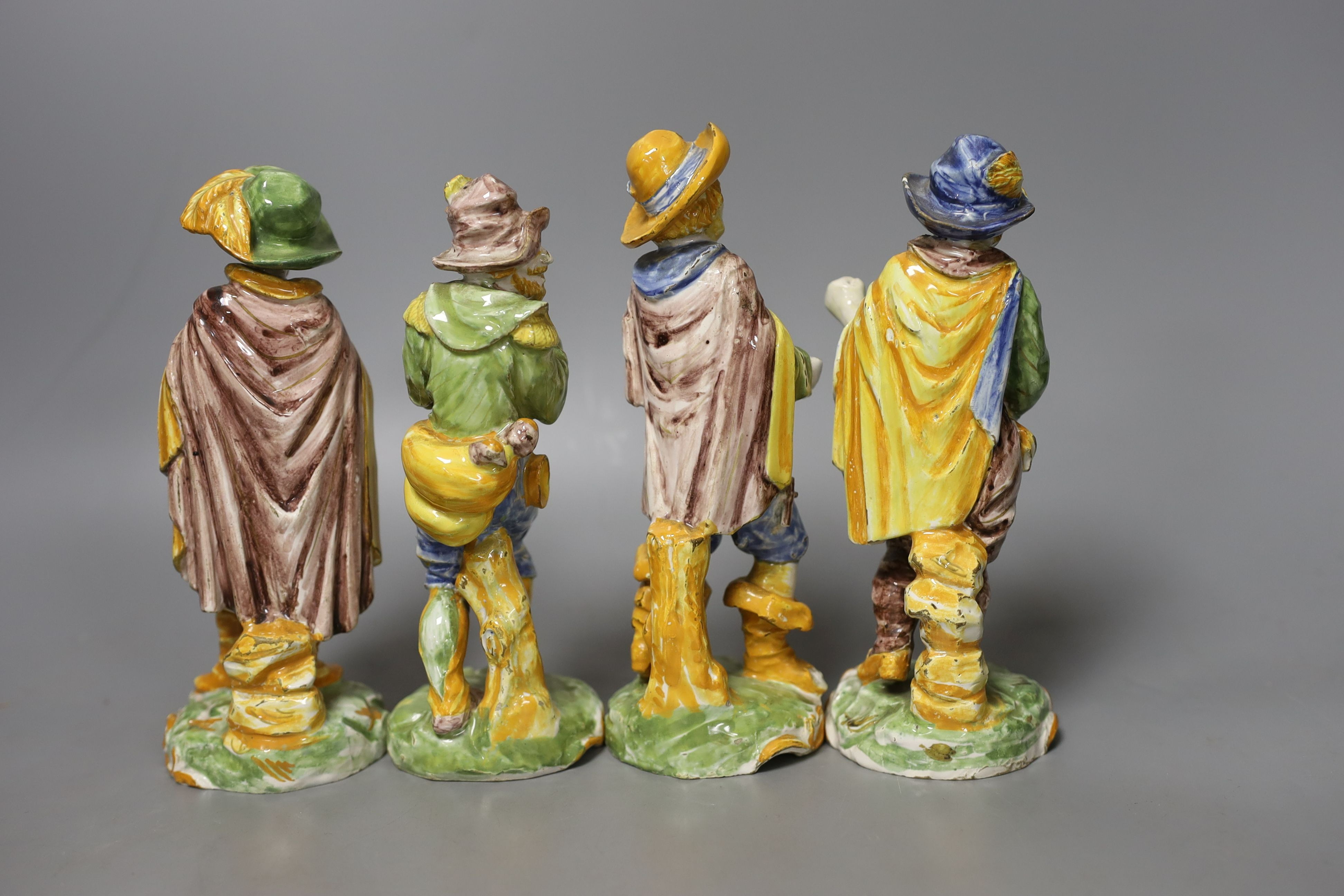 A set of four 19th century faience figures of street peddlers or performers - 18cm tall